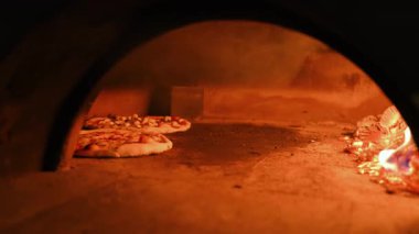  Tuğla fırında İtalyan pizzası, ahşap ateş ve dumanla, restoranda odun sobası. Yüksek kalite 4k görüntü