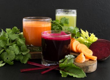 Sebze suyu cam bardak siyah bir arka plan. Pancar, kereviz, havuç