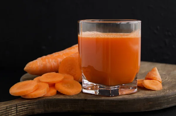 Freshly squeezed juice of carrots on black backgroun