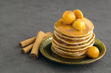 Zemin-kiraz ve gri bir arka plan üzerine tarçın ile Pancakes