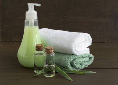 Sıvı sabun ve ahşap arka plan üzerinde iki havlu