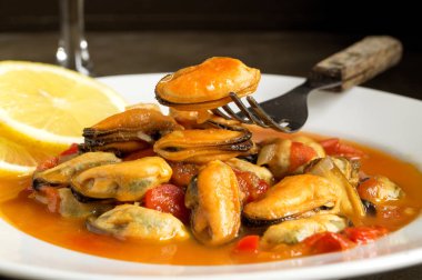 bir beyaz plat üzerinde domates soslu midye