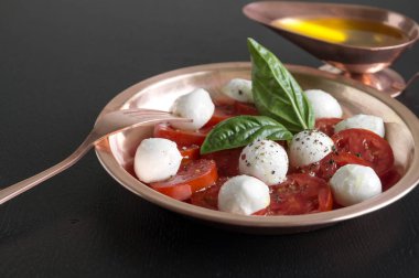 Olgun domatesli Caprese salatası ve taze fesleğen yapraklı mozzarella. İtalyan yemeği..