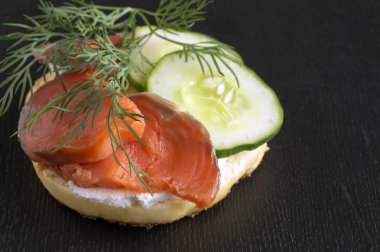 Simit krem peynir ve siyah bir adam üzerinde füme somon ile