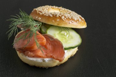 Simit krem peynir ve siyah bir adam üzerinde füme somon ile