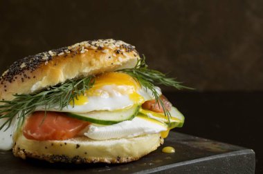 Simit yumurta ve siyah arka plan üzerine salatalık ile