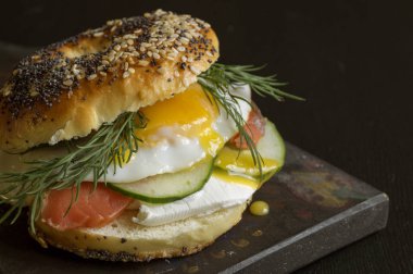 Simit yumurta ve siyah arka plan üzerine salatalık ile