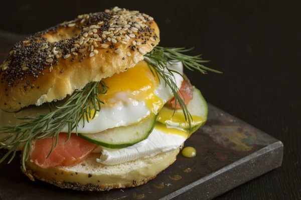 Simit yumurta ve siyah arka plan üzerine salatalık ile