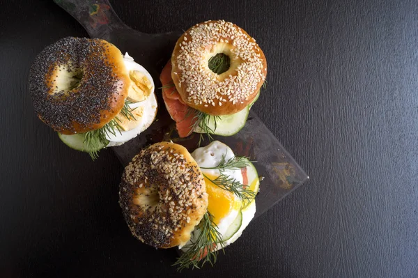 Simit yumurta ve siyah arka plan üzerine salatalık ile.