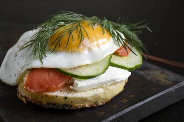 Simit krem peynir ve siyah bir adam üzerinde füme somon ile