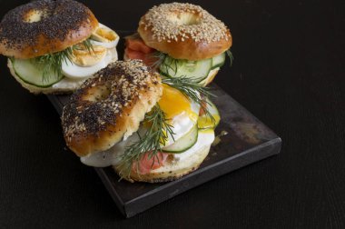 Simit krem peynir ve siyah bir adam üzerinde füme somon ile