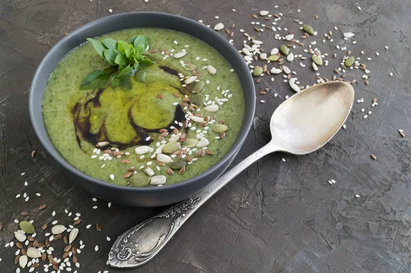 Vegetarian soup of green vegetables on a dark background