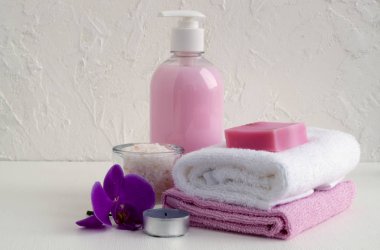 Sıvı sabun ve beyaz zemin üzerine iki havlu