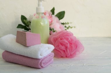 Sıvı sabun ve beyaz zemin üzerine iki havlu