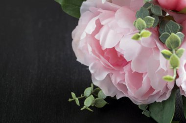 Siyah bir zemin üzerine pembe yapay peonies