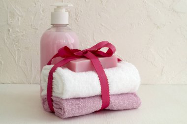 Sıvı sabun ve beyaz zemin üzerine iki havlu.