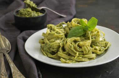 geleneksel İtalyan yemeği. pesto ile makarna. koyu arka planda.