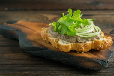 Kruvasan üzerine ev yapımı et ezmesi. koyu renk fotoğraf biçimi