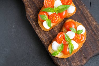 Olgun domatesli Caprese salatası ve taze fesleğen yapraklı mozzarella. İtalyan yemeği..