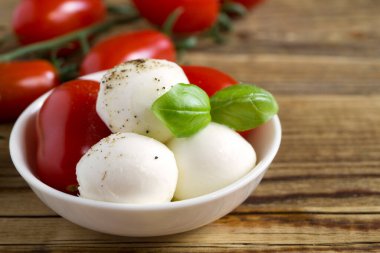 Olgun domatesli Caprese salatası ve taze fesleğen yapraklı mozzarella. İtalyan yemeği..