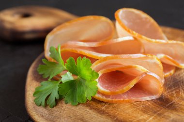 Tahtada ince dilimlenmiş füme jambon. et pürüzü