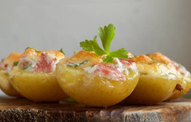 Peynirli fırında patates, pastırma, tahta üzerinde maydanoz..