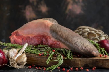 Doğrama tahtasındaki çiğ et dili. baharatlı.