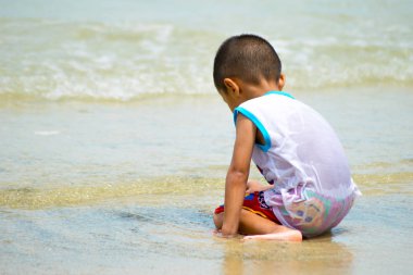 su sahilde oynarken çocuk