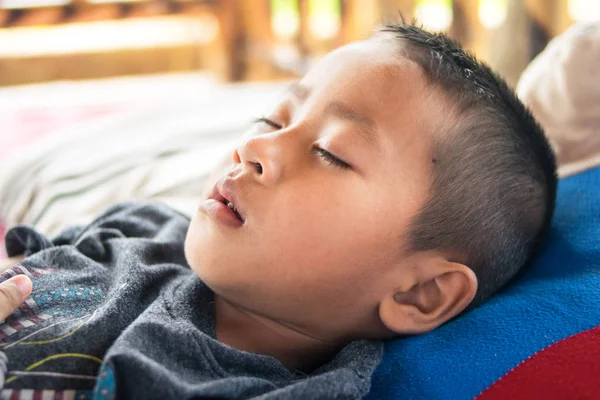 Asyalı çocuk yatakta uyuyor.