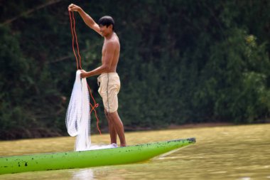 Sisaket doğa nehrinde tatlı su balıkları yakalamak için ağ döküm ahşap tekneasyalı balıkçı,Tayland 2018