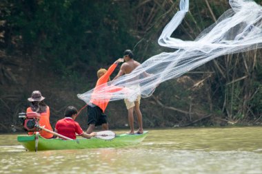 Sisaket doğa nehrinde tatlı su balıkları yakalamak için ağ döküm ahşap tekneasyalı balıkçı,Tayland 2018
