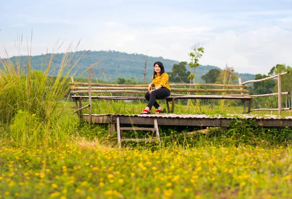 Sarı Çiçek Alanında Ahşap Sandalyede Güzel Kız — Stok fotoğraf
