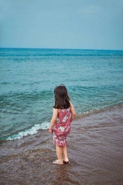 Antalya'da deniz side Beach mavi su clowdy günü ile oynayan çocuklar