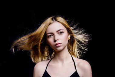 Adil saçlı Genç ve güzel kız. Sarışın kadın kamera bakmak. Stüdyo çekimi. Siyah arka plan. Siyah elbise giymiş. Iris gözler. Genç erkek portresi. Kıvırcık saçlı güzel model.