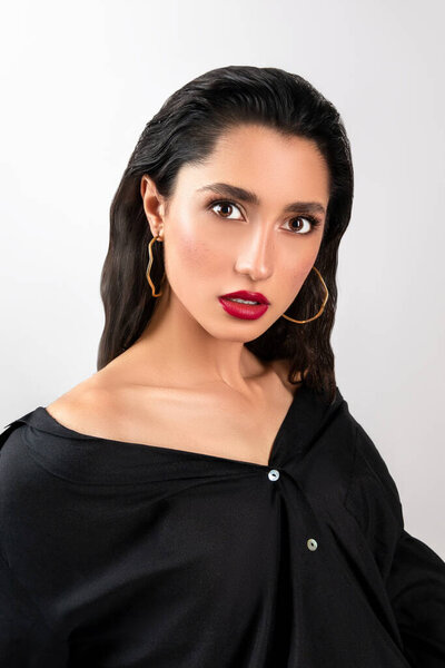 Beautiful young girl portrait. Female in black shirt. Grey solid background. Bright makeup with red lips. Sexy female