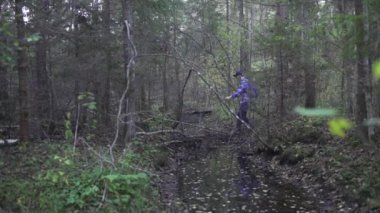Ormanda yürüyen genç bir adamın görüntüleri.