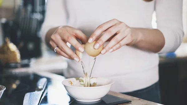 En ung kvinna bowling ett ägg i en skål — Stockfoto