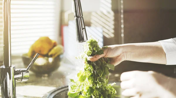 En kvinna tvättar grönska neetle i köket — Stockfoto