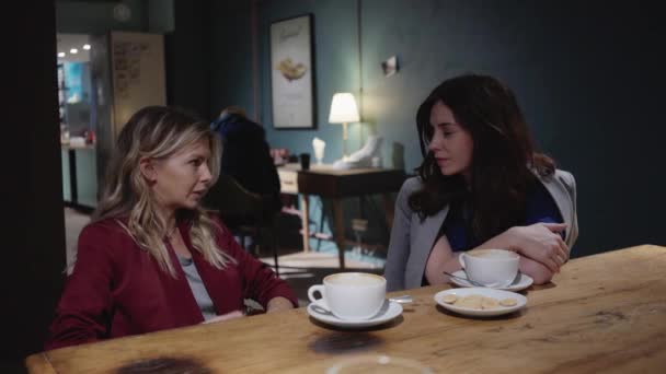 Два молодых привлекательных друга разговаривают в кафе, девушка власть и слушать — стоковое видео