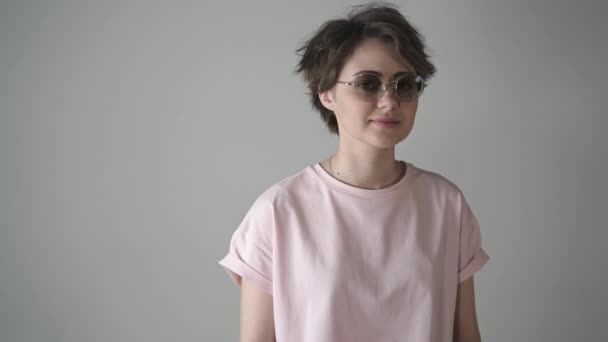 Hipster meisje in zonnebril draaien haar hoofd en het glimlachen — Stockvideo