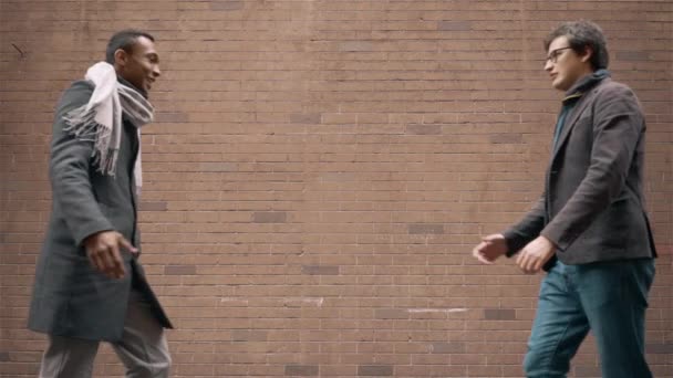 Два молодых бизнесмена встречаются на улице и пожимают друг другу руки — стоковое видео