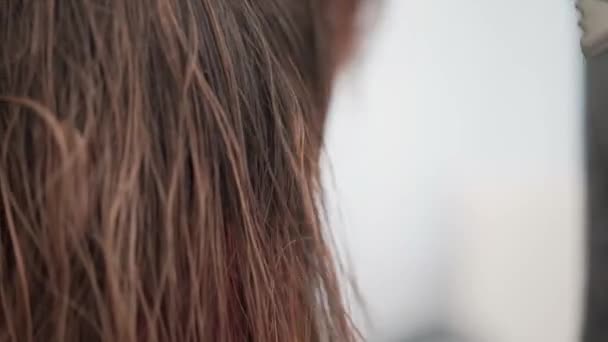 Unerkennbare junge Friseurin trocknet ihren Kunden die Haare — Stockvideo