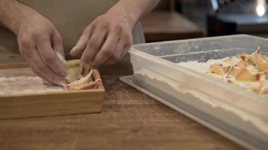 Tortellini çiçek ve Satılık Ahşap bir tepsi içine koyarak bir adamın elleri