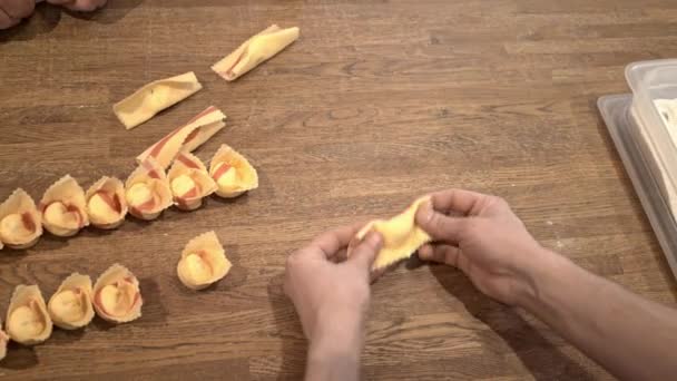 Duas pessoas fazendo tortellini comida tradicional italiana, vista superior deslizante tiro — Vídeo de Stock