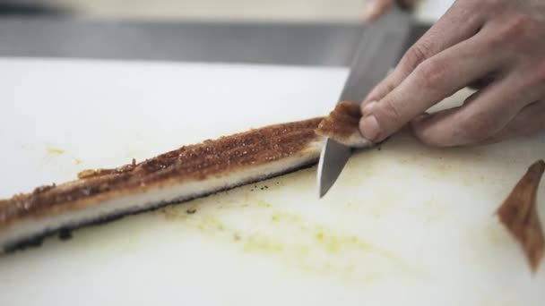 Cuire le poisson coupant pour les sushis dans un restaurant, panoramique — Video