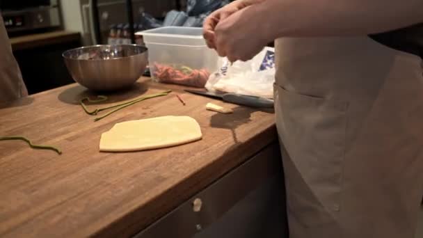 Шеф-повар помещает зеленые полоски теста на белое тесто в ресторане — стоковое видео