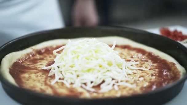 Chef poniendo queso en la pizza en una pizzería — Vídeos de Stock