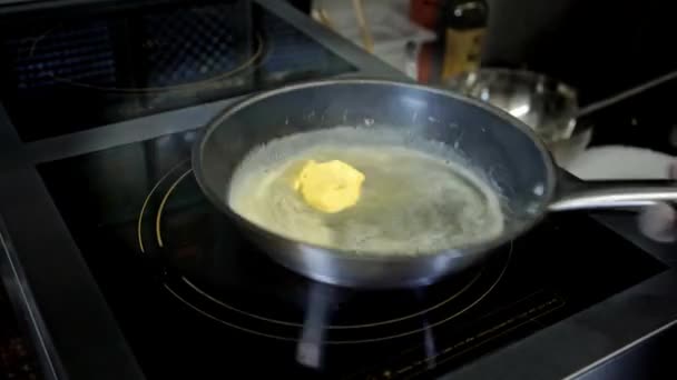 Bucătarul topește o bucată de unt pe o tigaie într-un restaurant — Videoclip de stoc