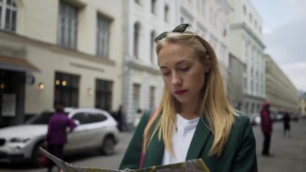 Туристка-блондинка смотрит на карту прогуливающейся по Москве возле Кремля — стоковое видео