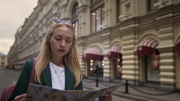 Turista loira olhando para o mapa caminhando no centro de Moscou, Rússia verão — Vídeo de Stock